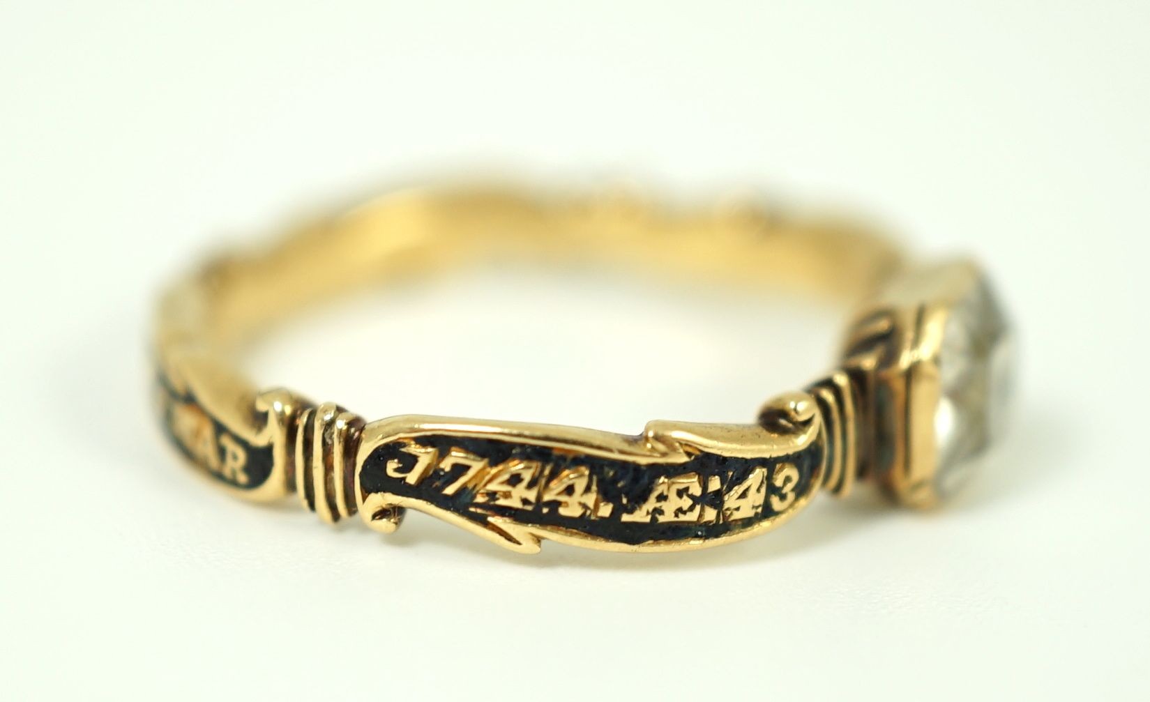 A George II gold, black enamel and rock crystal set mourning ring